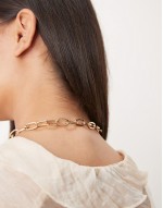 necklace with t-bar and puff heart charm detail in gold tone